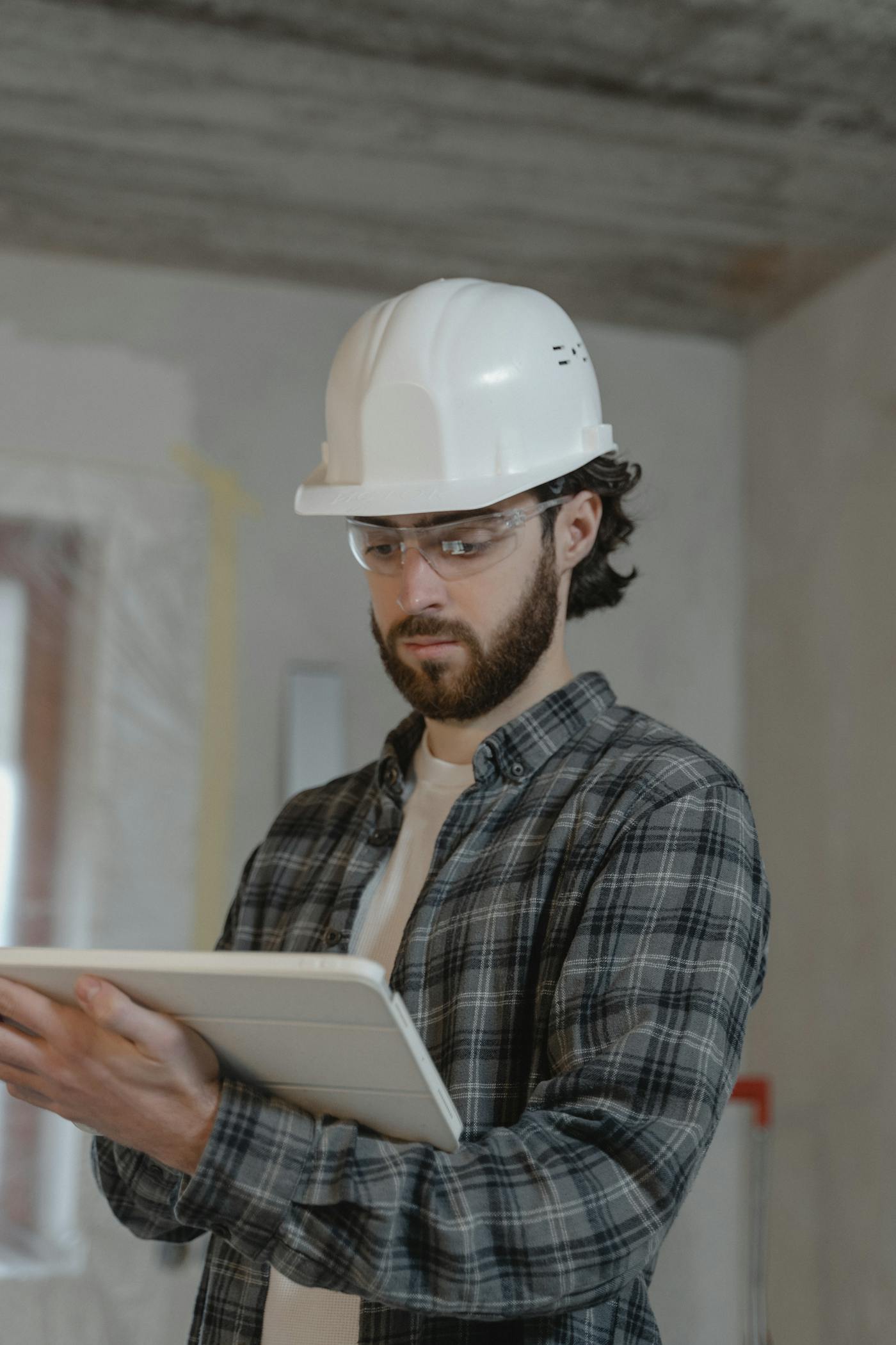 Engineer in hard hat reviewing building plans